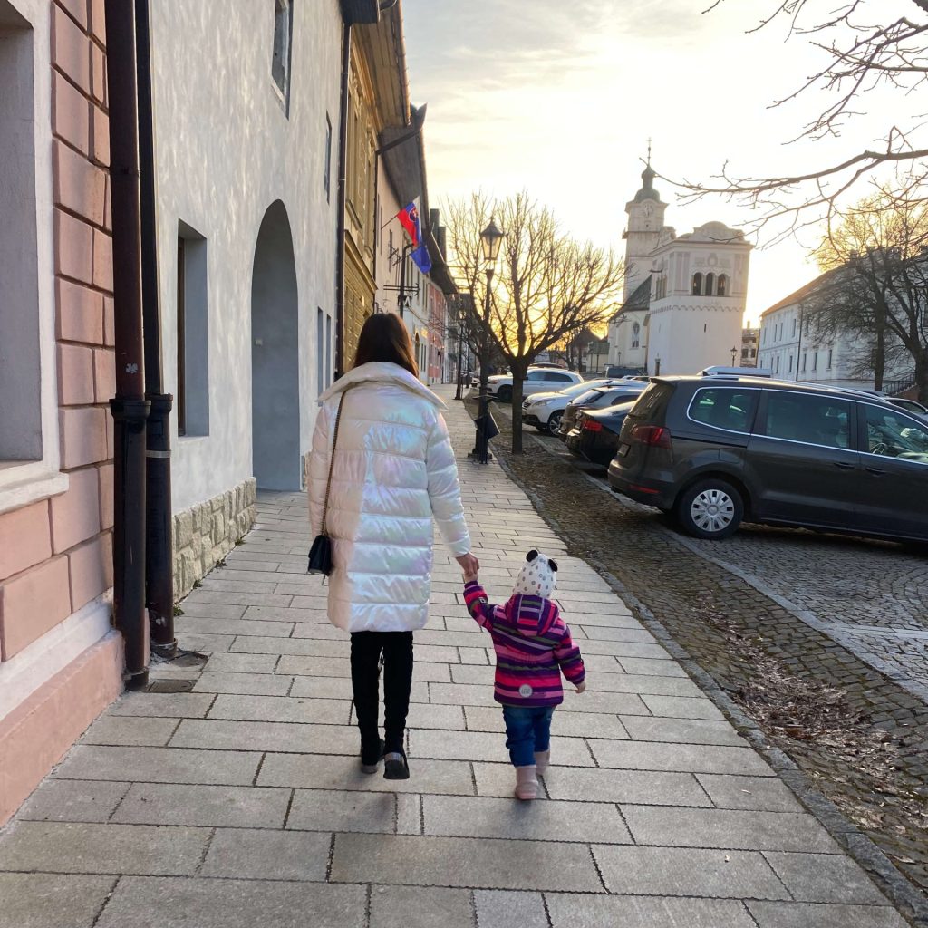 baby walking with mother on a street