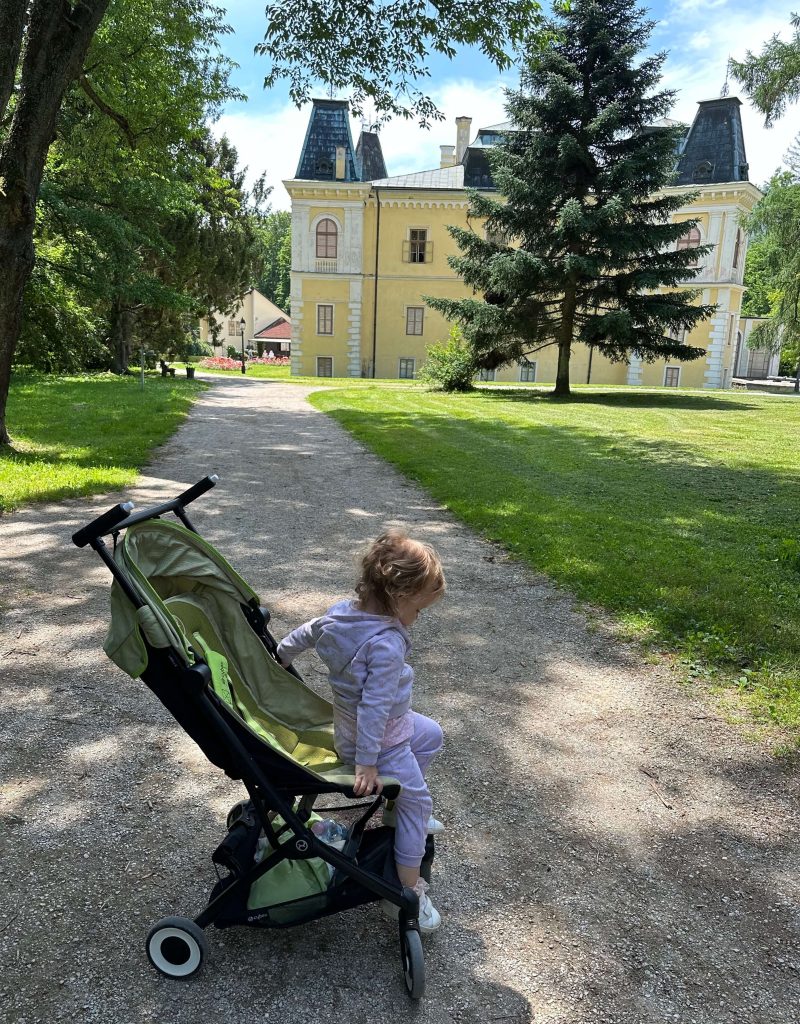 baby stroller and a baby in front of a castle