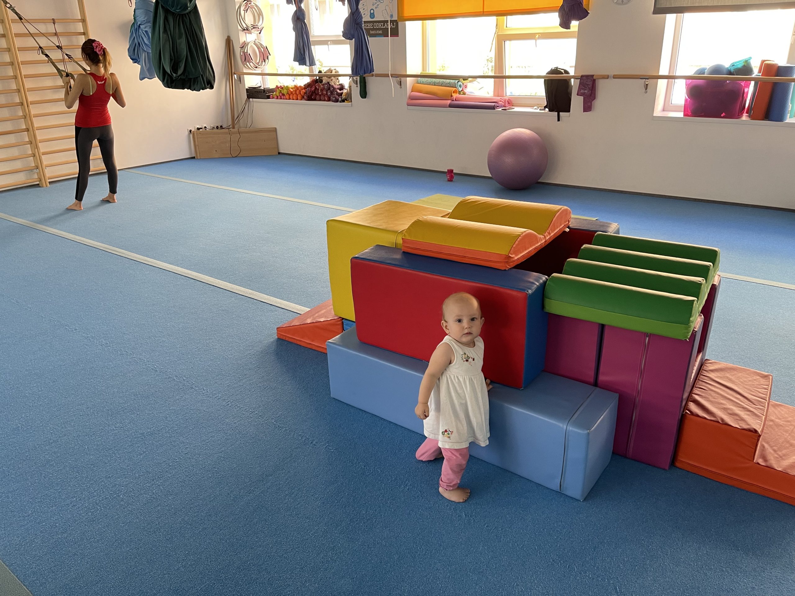 baby playing in a gym while mother is working out