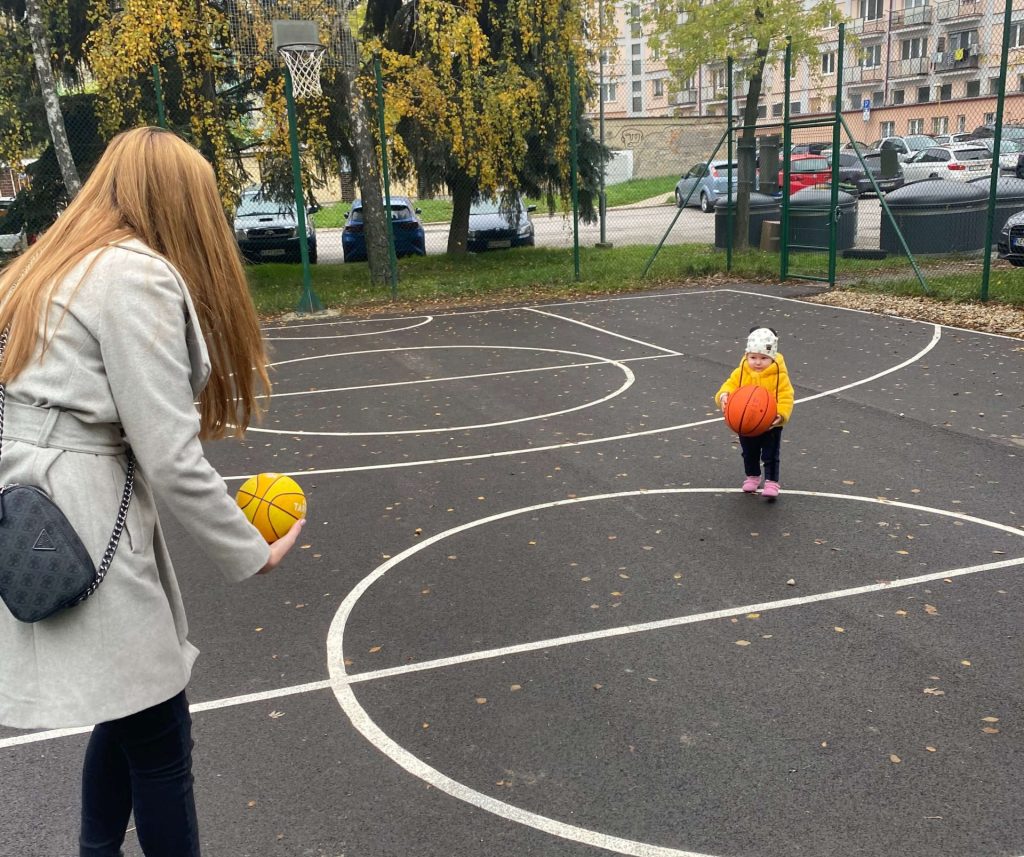 a girl and a baby playing basketball